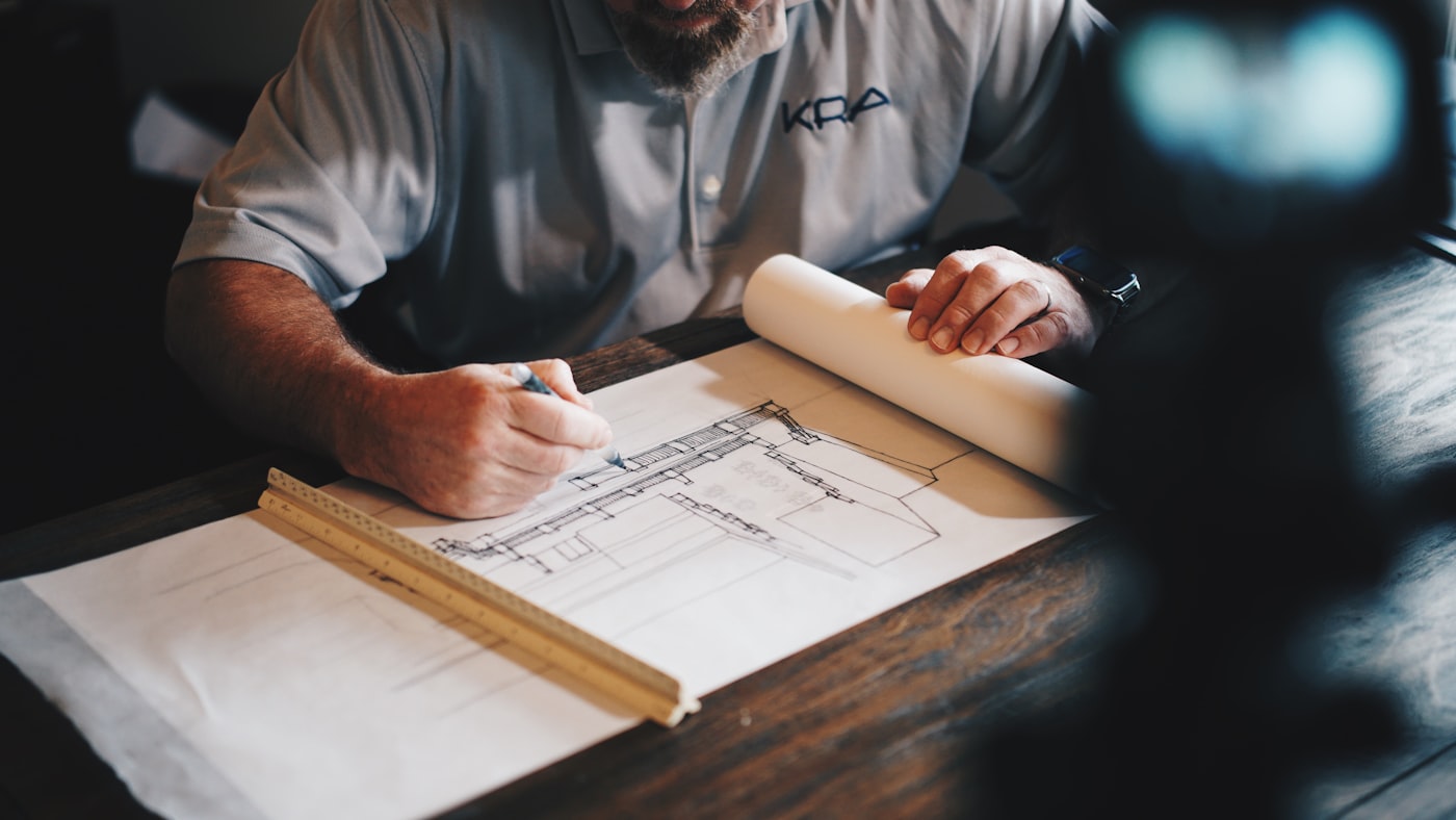The owner reviewing an elevation drawing at the drafting table before a build